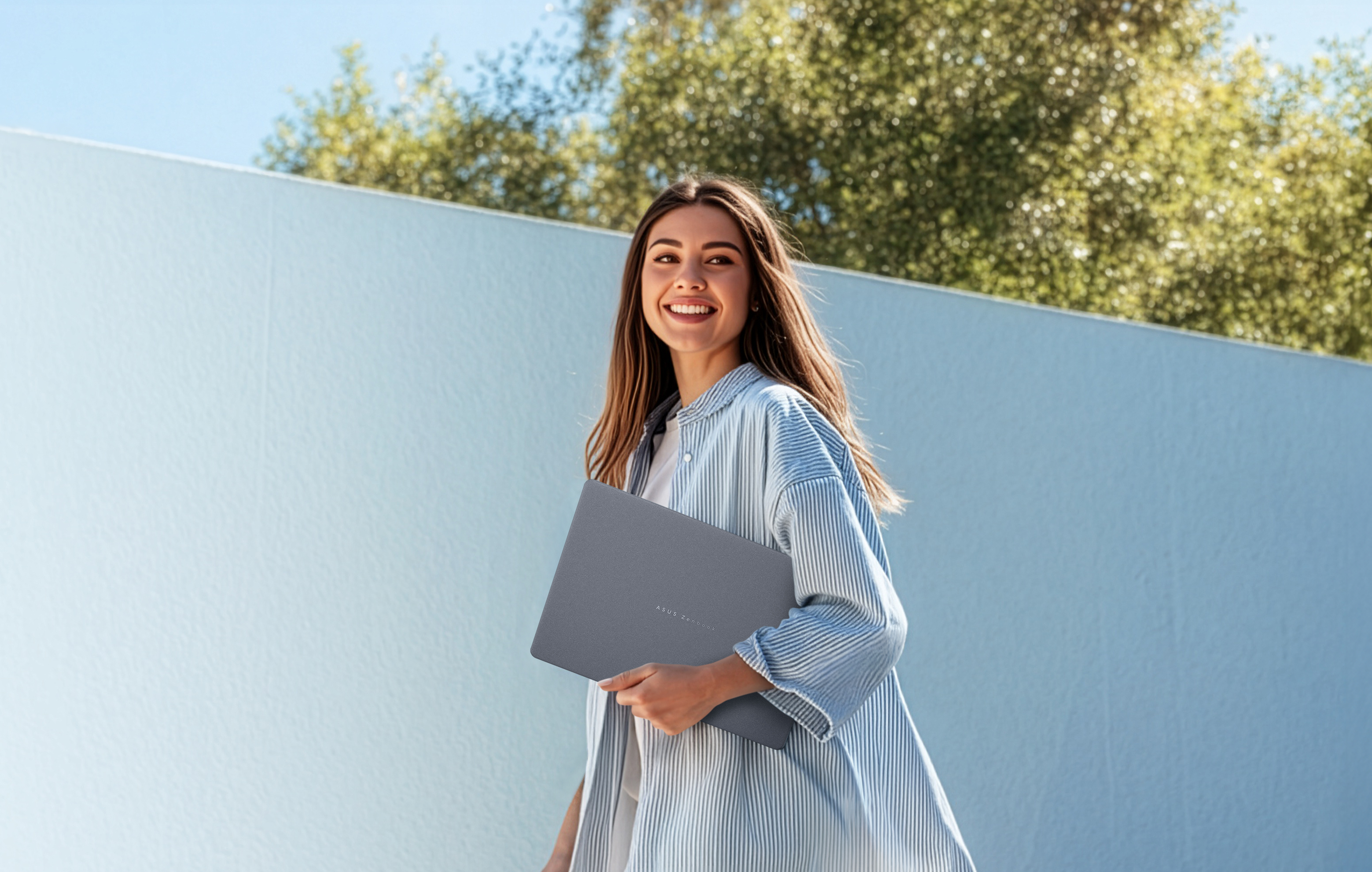 uśmiechnięta kobieta niesie laptopa Zenbook 14